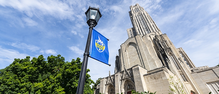Cathedral of learning with Pitt shield banner in foreground