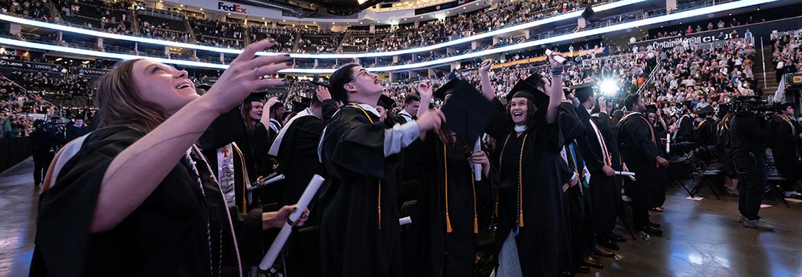 Graduating students toss their caps in the air to celebrate during the Spring 2025 commencement.